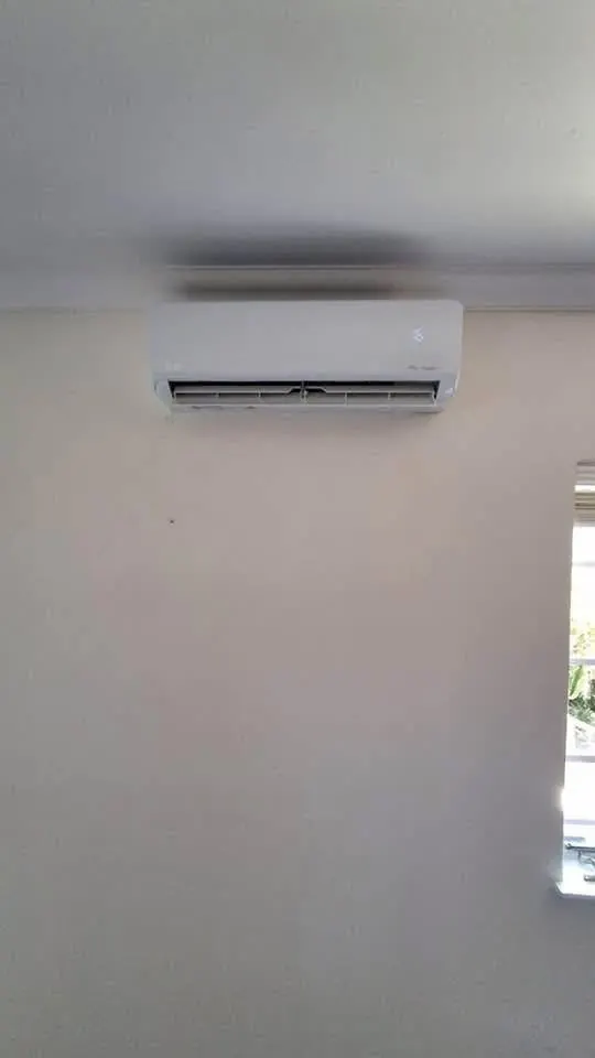 Aircon indoor unit mounted high on a plain wall